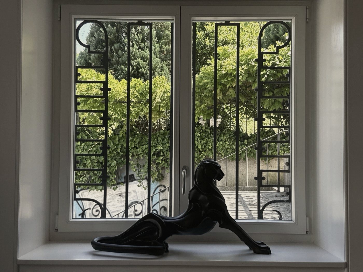 Panther-Skulptur am Fenster zum Garten